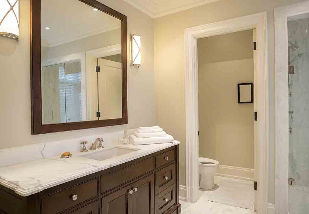 اختر مرآة الحمام اصغر من عرض الخزانة بمسافة قليلة لتسمح لك بتركيب ابليك فى الحائط على جوانب المرآة